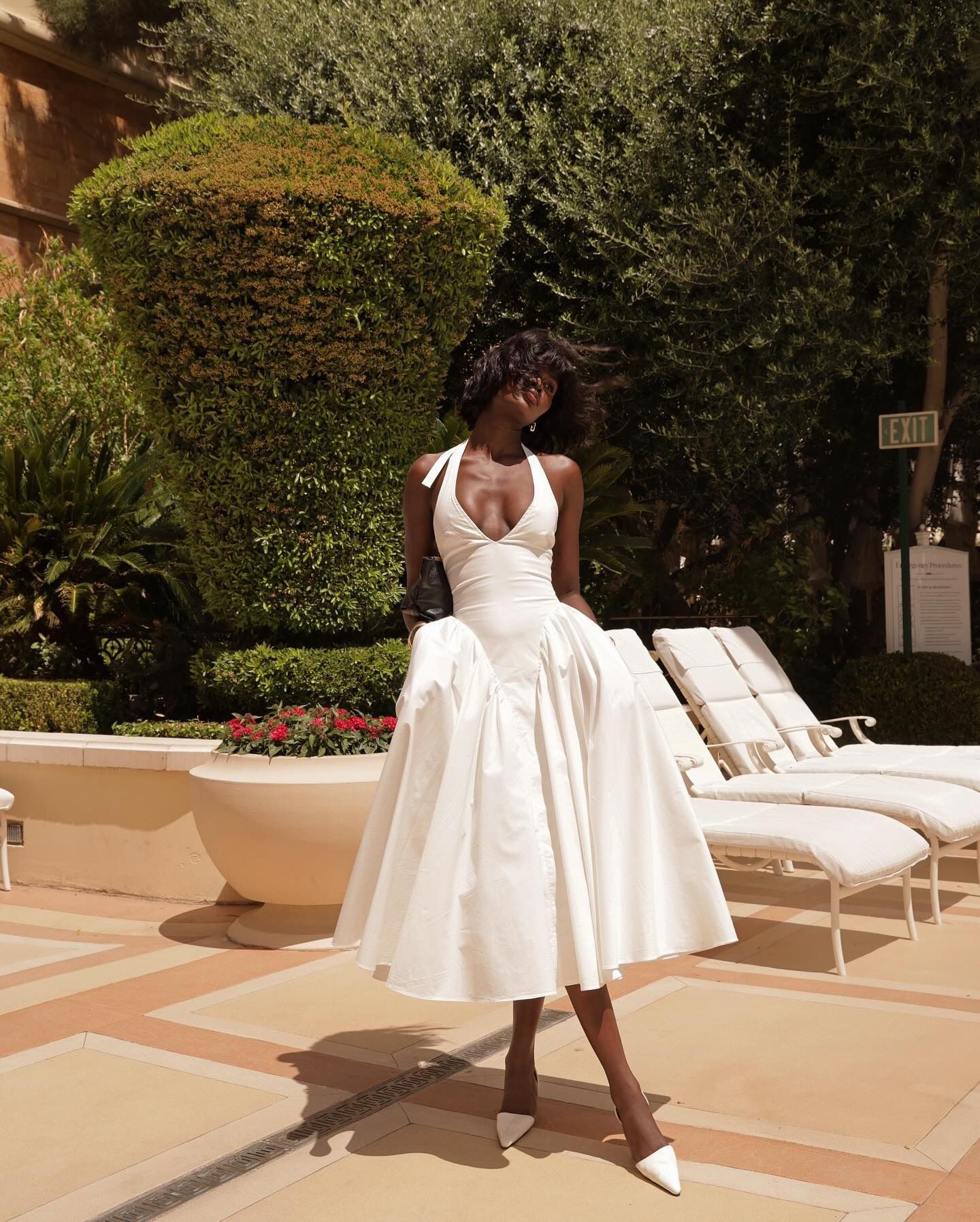 Amy Julliette Lefévre wears halterneck white dress in Las Vegas by the pool.