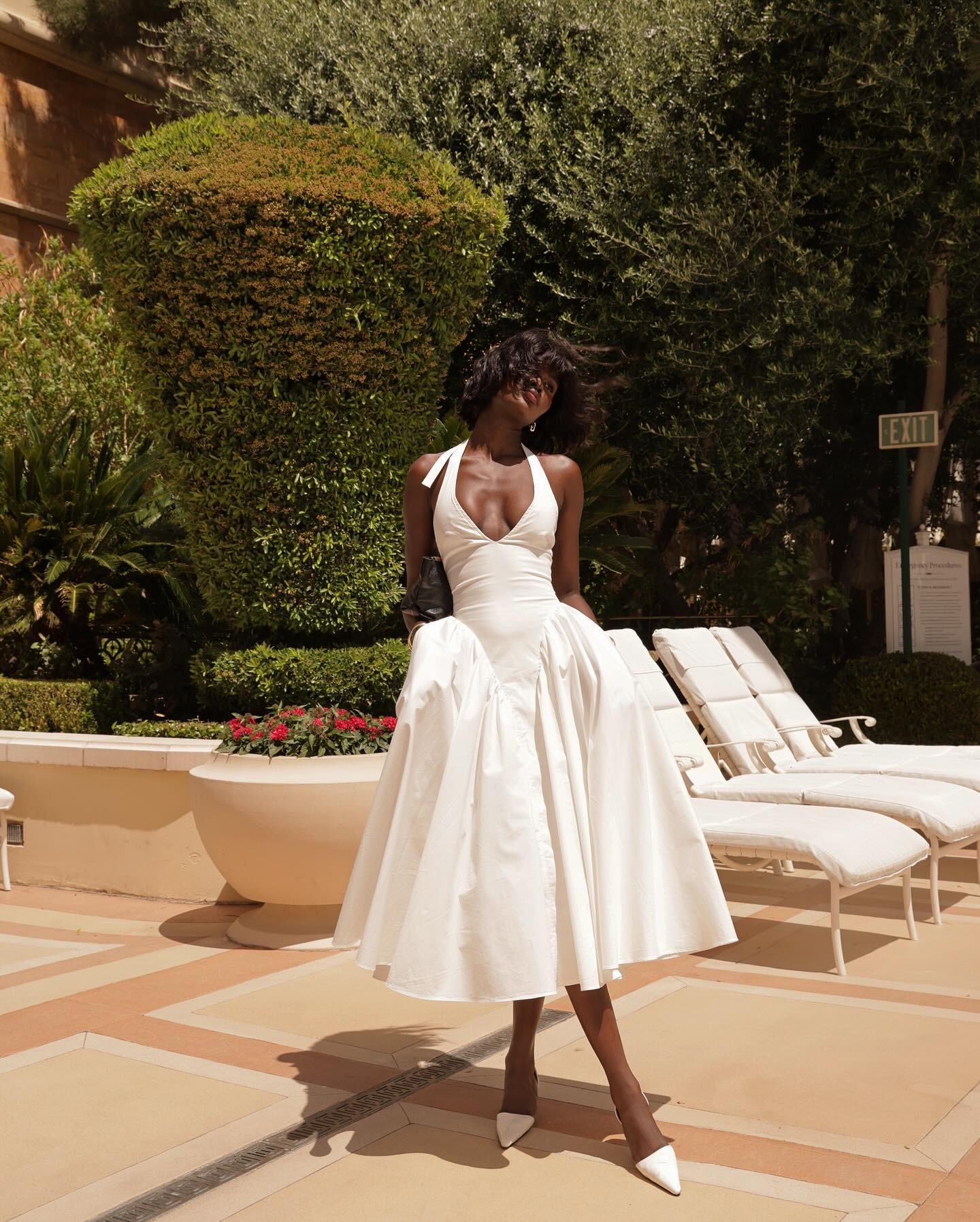 Amy Julliette Lefévre wears halterneck white dress in Las Vegas by the pool.