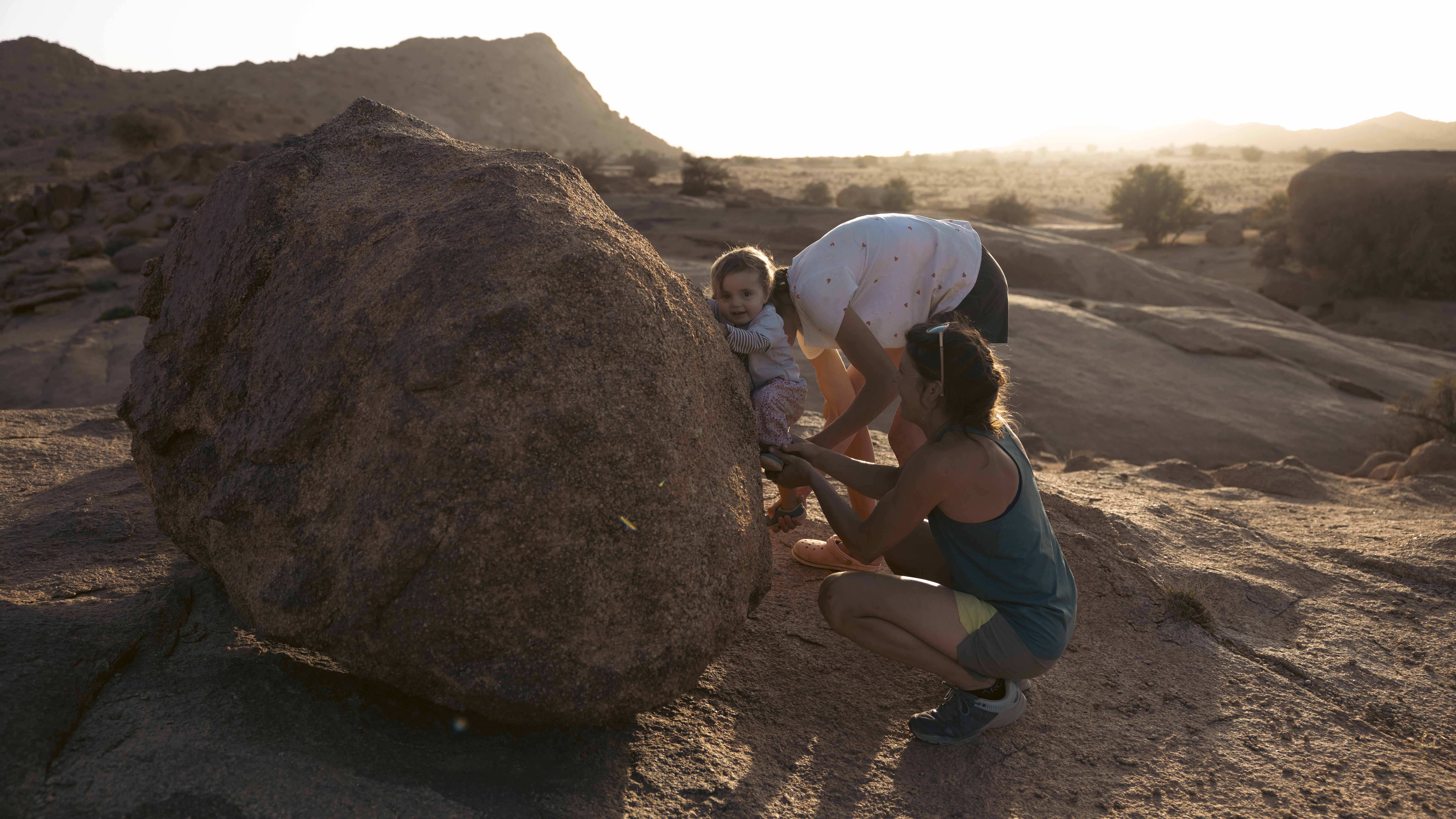 Child climbing boulder