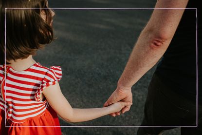 Close up of child holding hands with parent