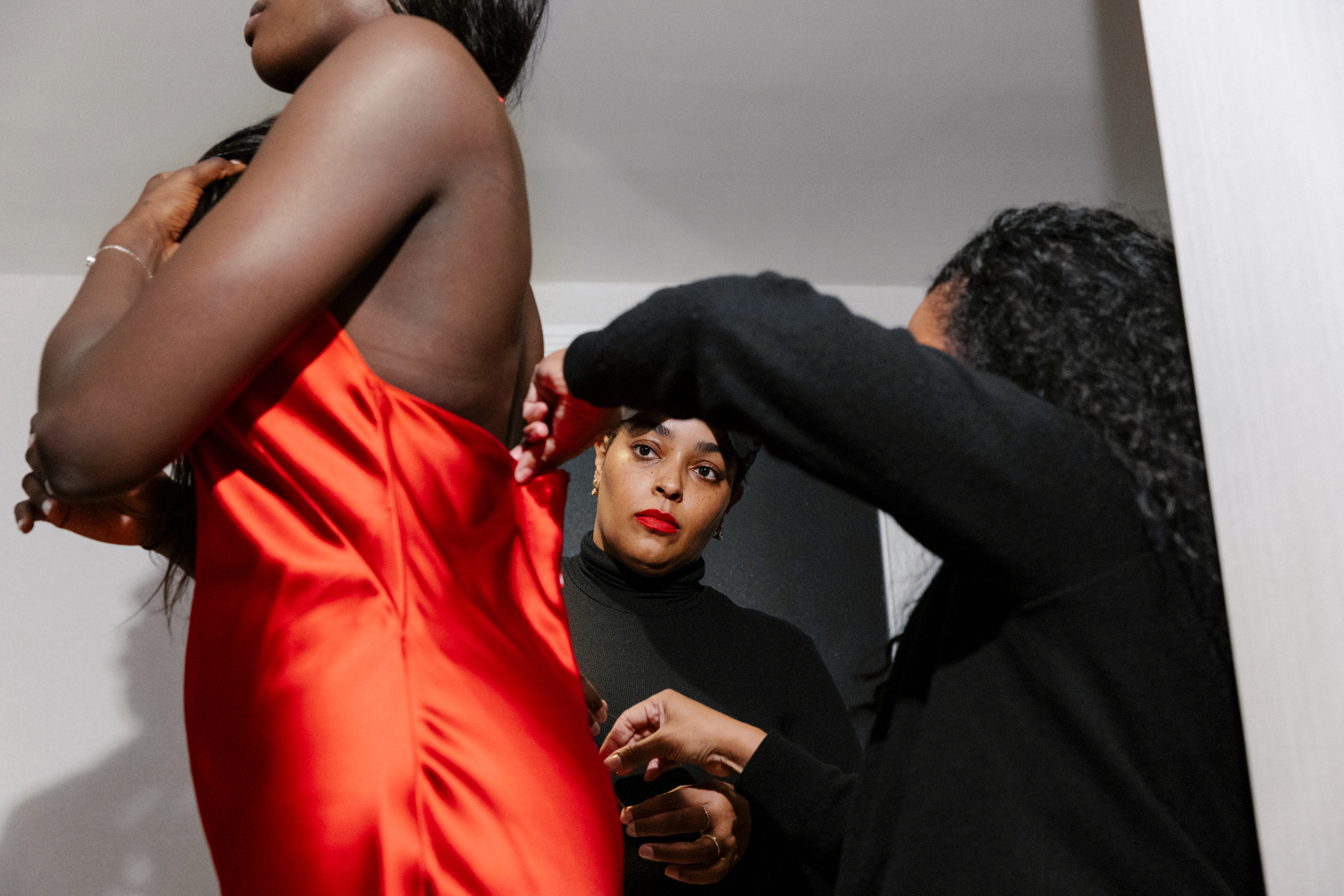 Awa Fam getting ready for the 2026 WNBA Draft with stylist Courtney Mays wearing a red Siedres dress from Shopbop.