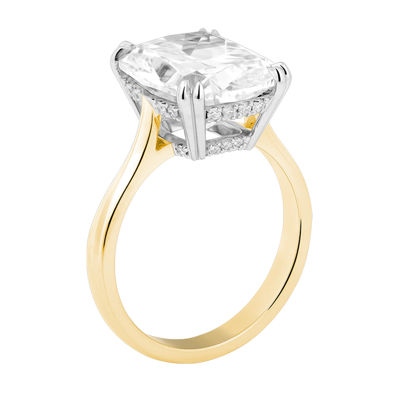 an engagement ring with a gold band and elongated cushion cut solitaire diamond