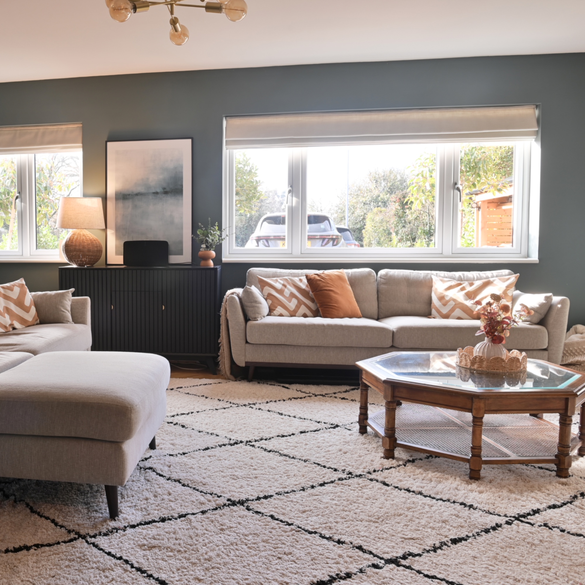 blue living room with beige L shaped sofa and 3 seater, coffee table, rug
