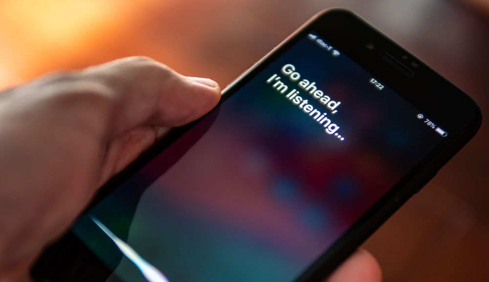 Siri presenting 'Go ahead, I'm listening' in text on iPhone screen.