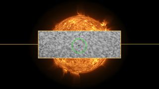 a view of the hubble space telescope crossing the sun with a view of the sun behind.
