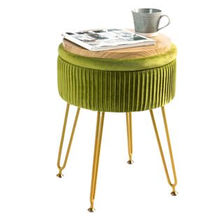 A green storage ottoman with a magazine and coffee on top