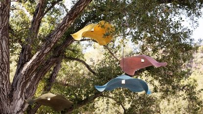 a tree suspending three rattan outdoor pendant lights