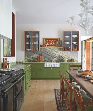 large kitchen with green cabinetry and marble and white walls