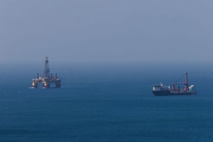 Oil stocks: a offshore oil platform and a support vessel at sea