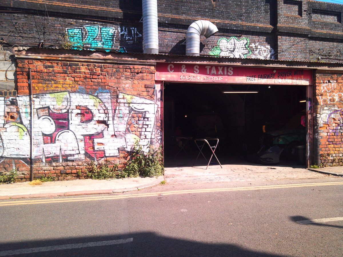 Camp Snap CS-Pro sample image showing garage next to graffiti-covered wall, colors are warm and red-toned