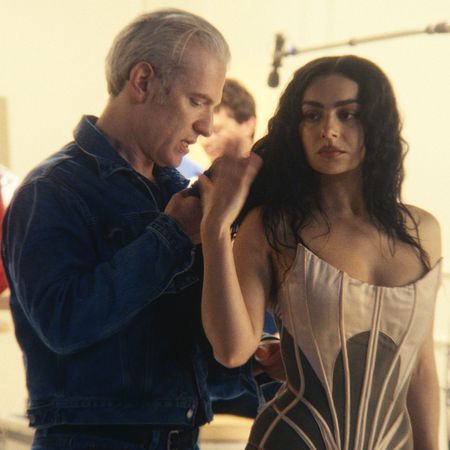 charli xcx is fitted by mel ottenberg into a baby pink tight corset in a dressing room in a still from the movie the moment