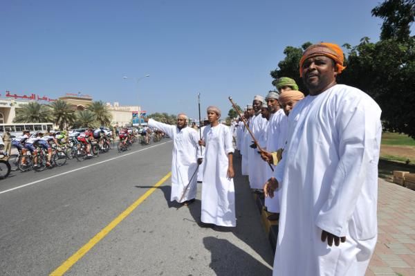 Omani people watch the peloton pass