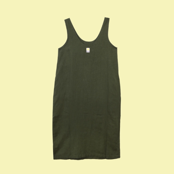 A forest green linen dress with no sleeves sat against a pale yellow background.