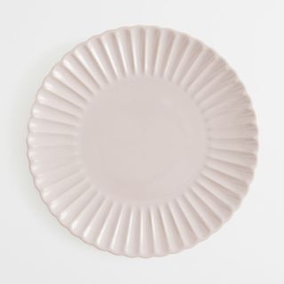Pink scalloped plate on white background