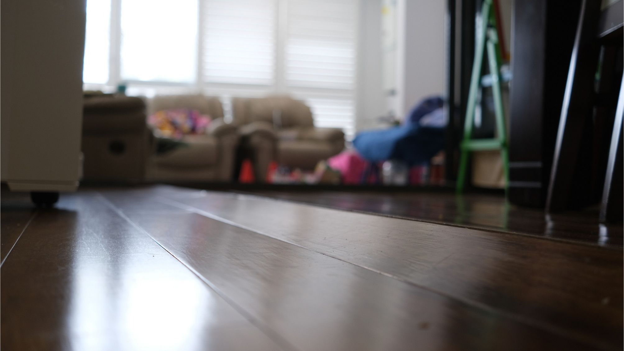 Corrugated wooden floor due to expansion at Living room.