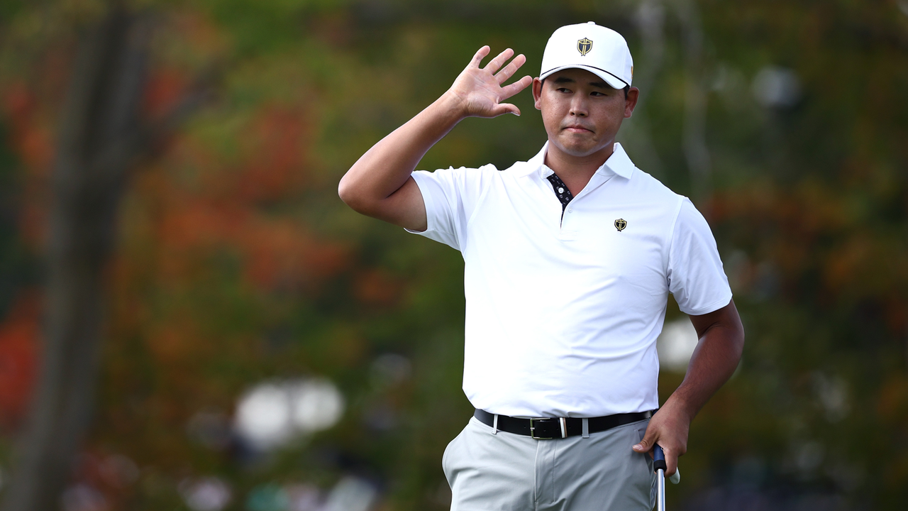 Si Woo Kim holds his hand to his ear after holing his putt