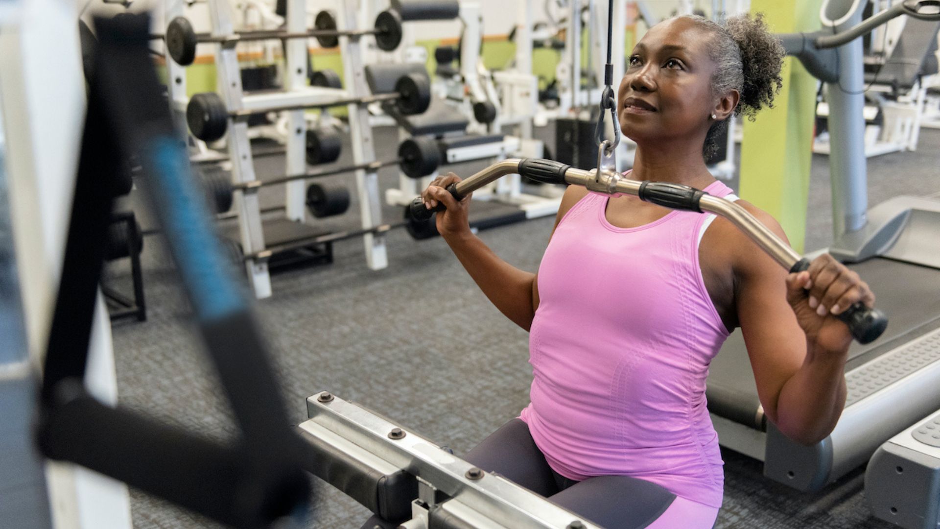 Woman using lat pulldown machine at the gym
