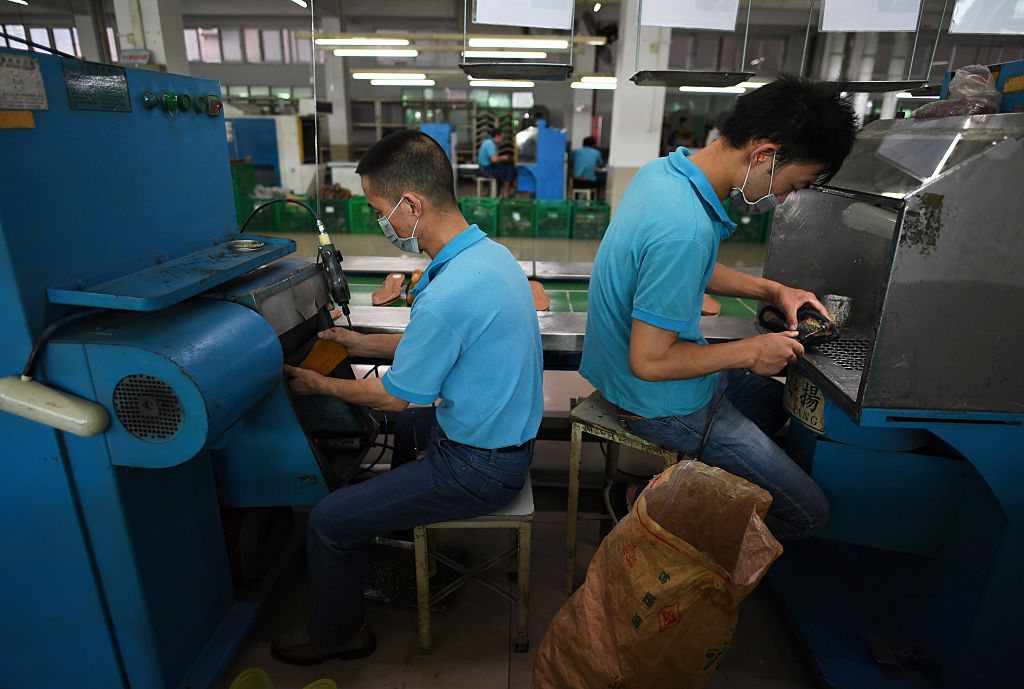 Men making shoes in factory.