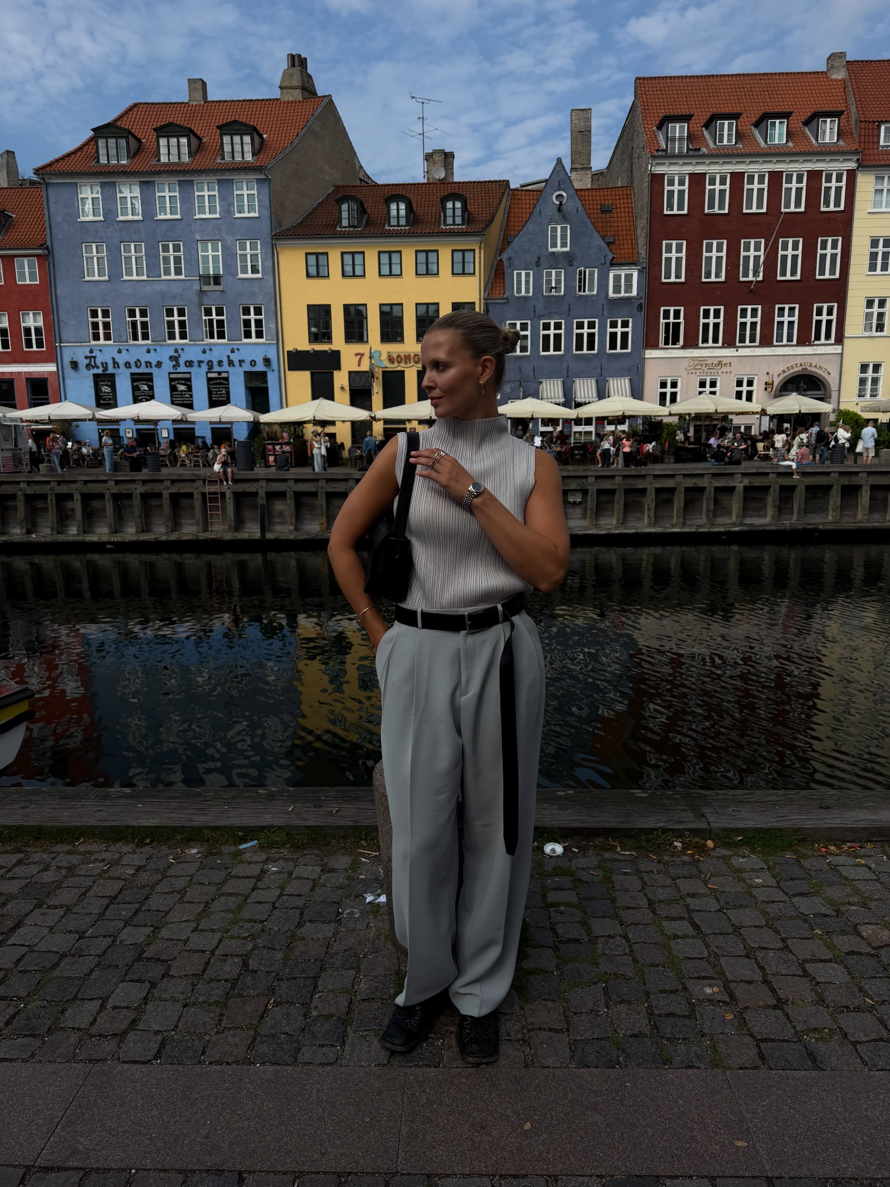 Influencer Hollie Mercedes wearing blue tailored trousers with a pleated top.