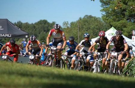 The elite men men crest a small rise before the drag race to the first singletrack.