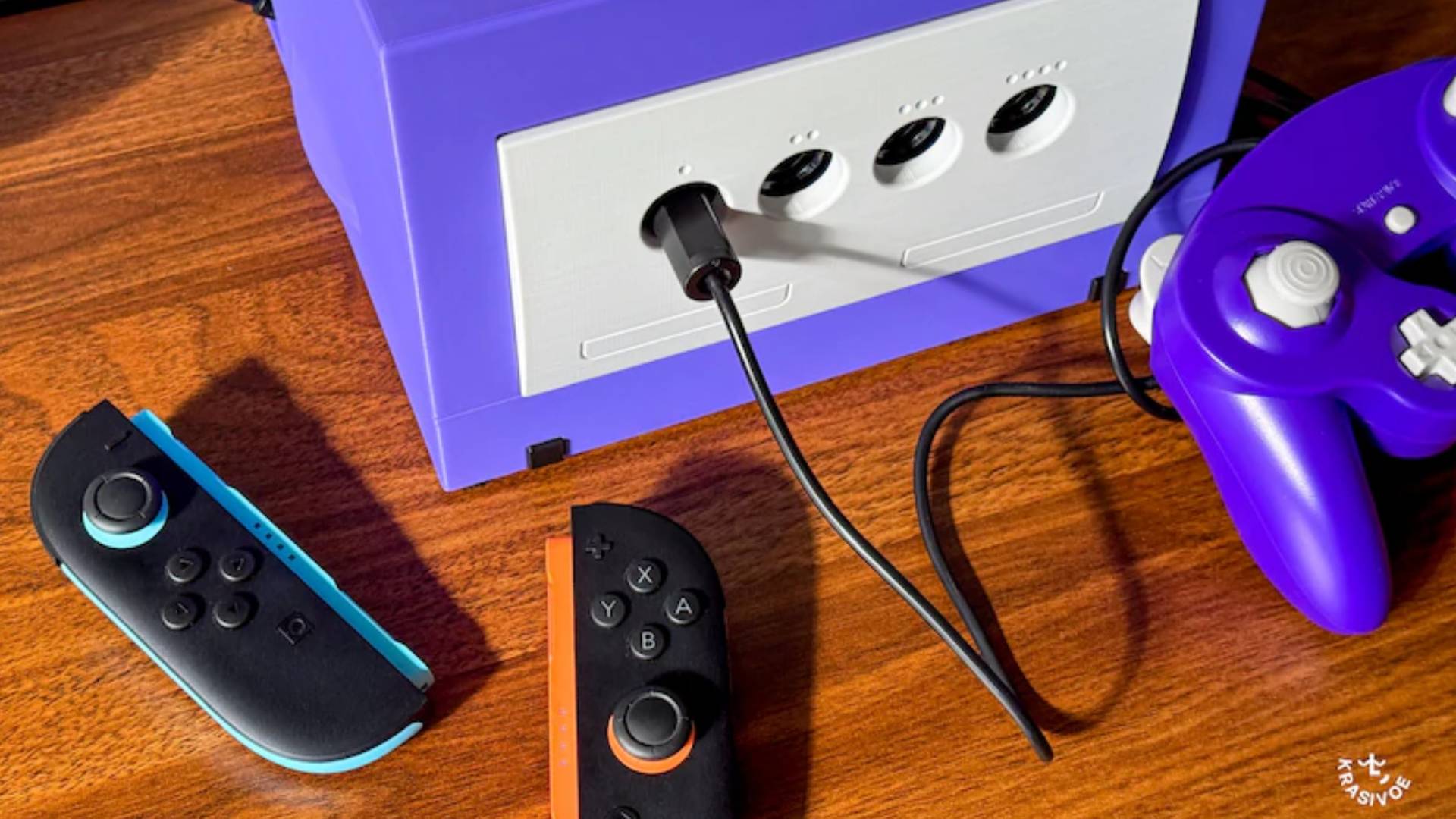 Official marketing image showing a set of Switch 2 Joy-Con sitting next to the Krasivoe Cubedock.