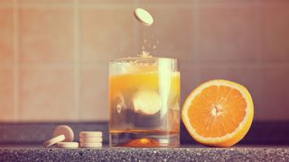 Artistic shot of vitamin C family, orange, tablet stack, dissolving tablet