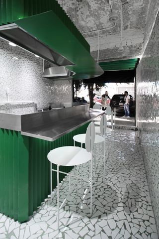 White bar stools at green bar with steel bar-top in mosaic tiled interior of Taqueria Los Alexis, designed by RA!, in Mexico CityTaqueria Los Alexis, designed by RA!, in Mexico City