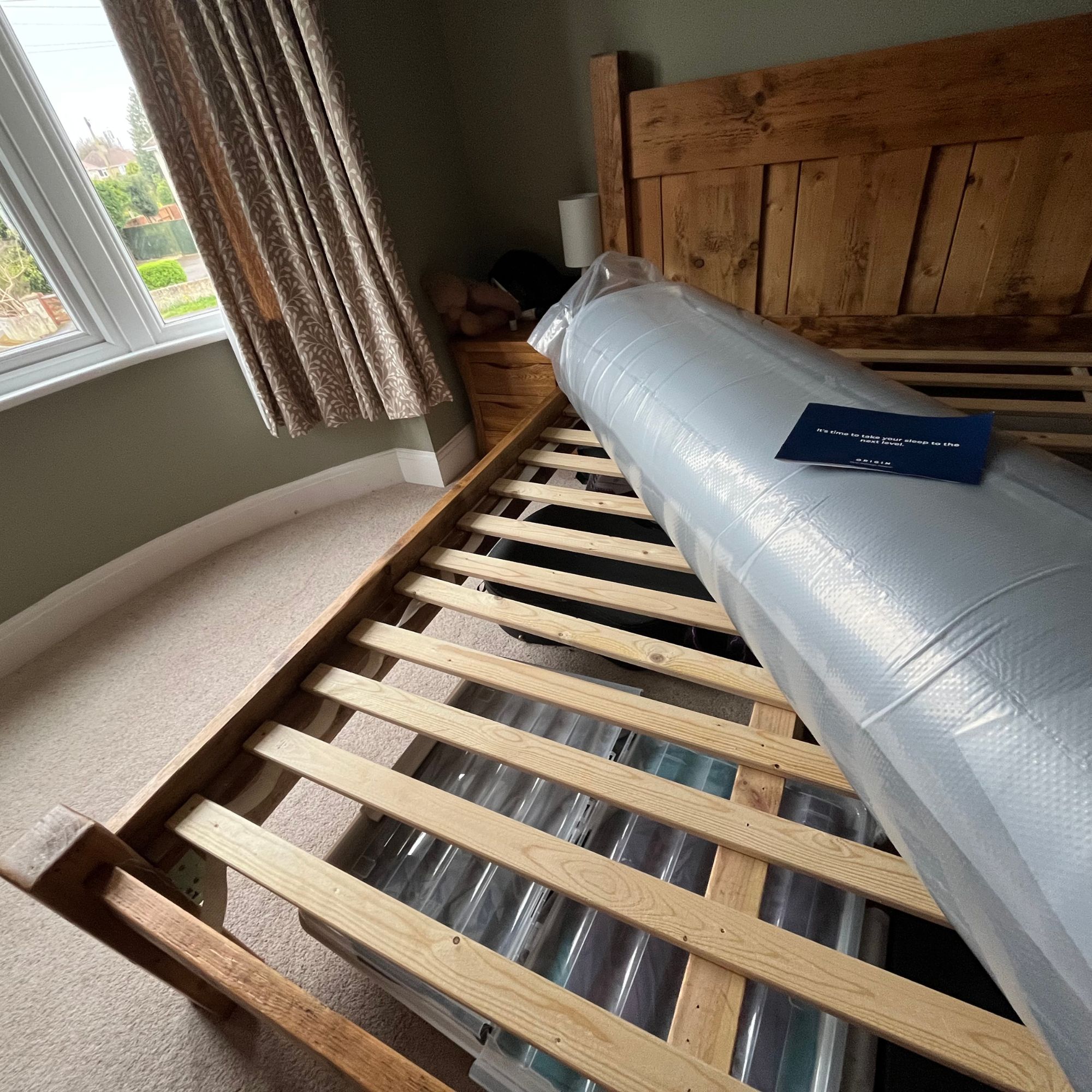 Origin LumbarCloud mattress wrapped in plastic on bed frame