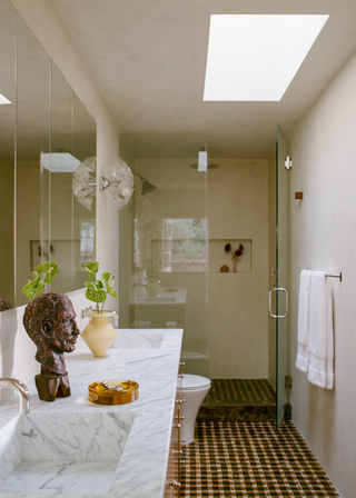 Bathroom with checkerboard tiles and bust on marble countertop