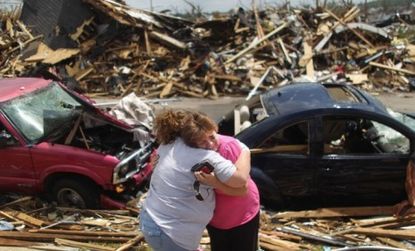 Survivors of the deadly tornado in Joplin, Mo., hug in front of the wreckage: The severe storms that ripped through the U.S. in April and May inflicted an estimated $14.5 billion in damage.