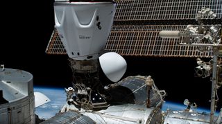 a white cylindrical space station seen against the blackness of space