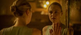 Polly holding hand up to mirrored reflection in Vicious