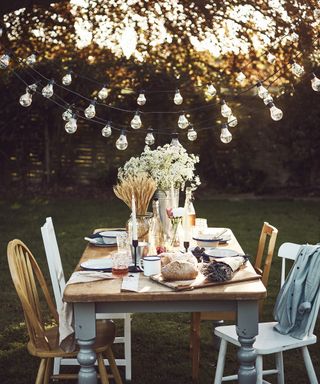 A tablescape created in the evening in a garden with festoon lights