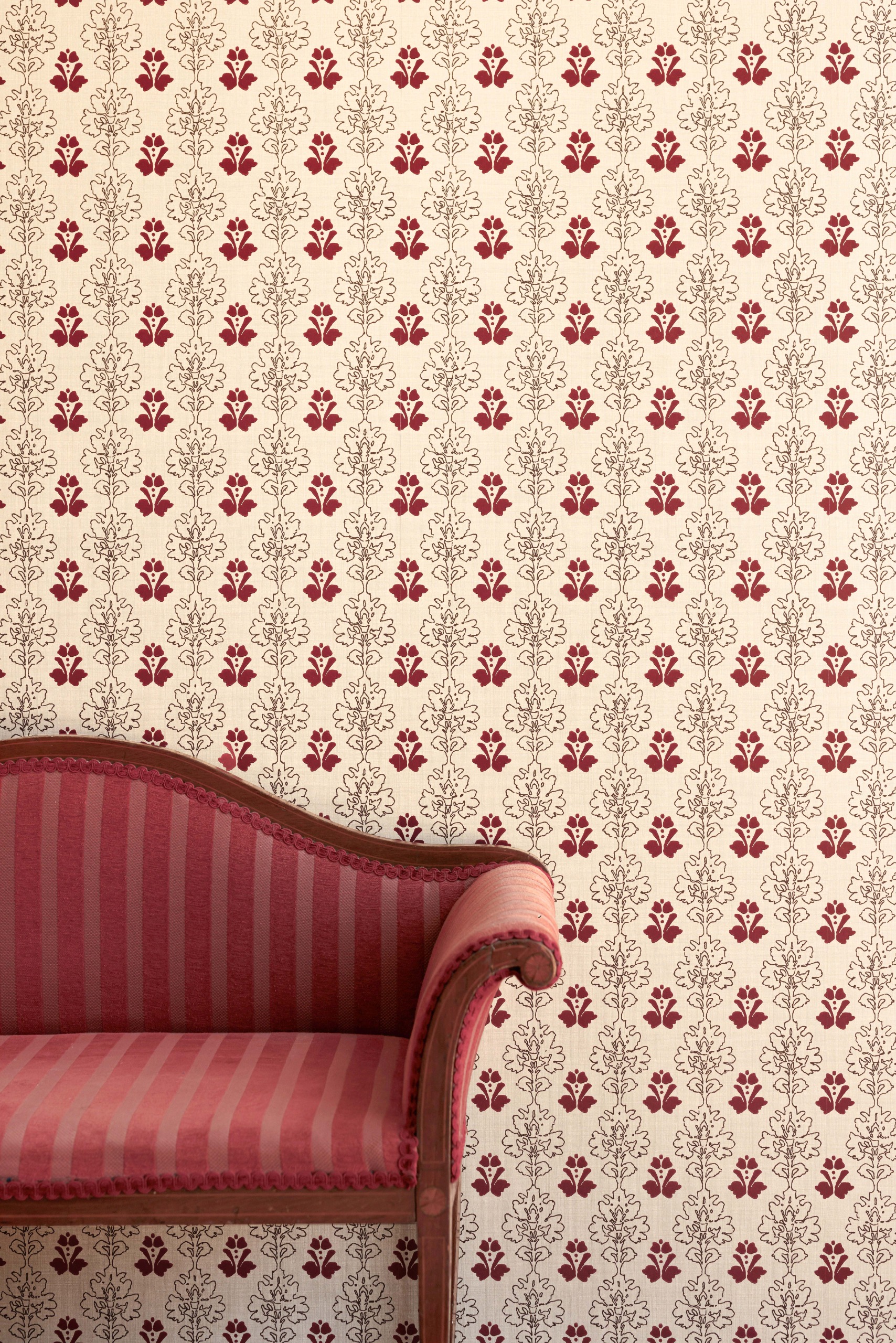Block-print wallpaper in red and chocolate brown tones, on cream