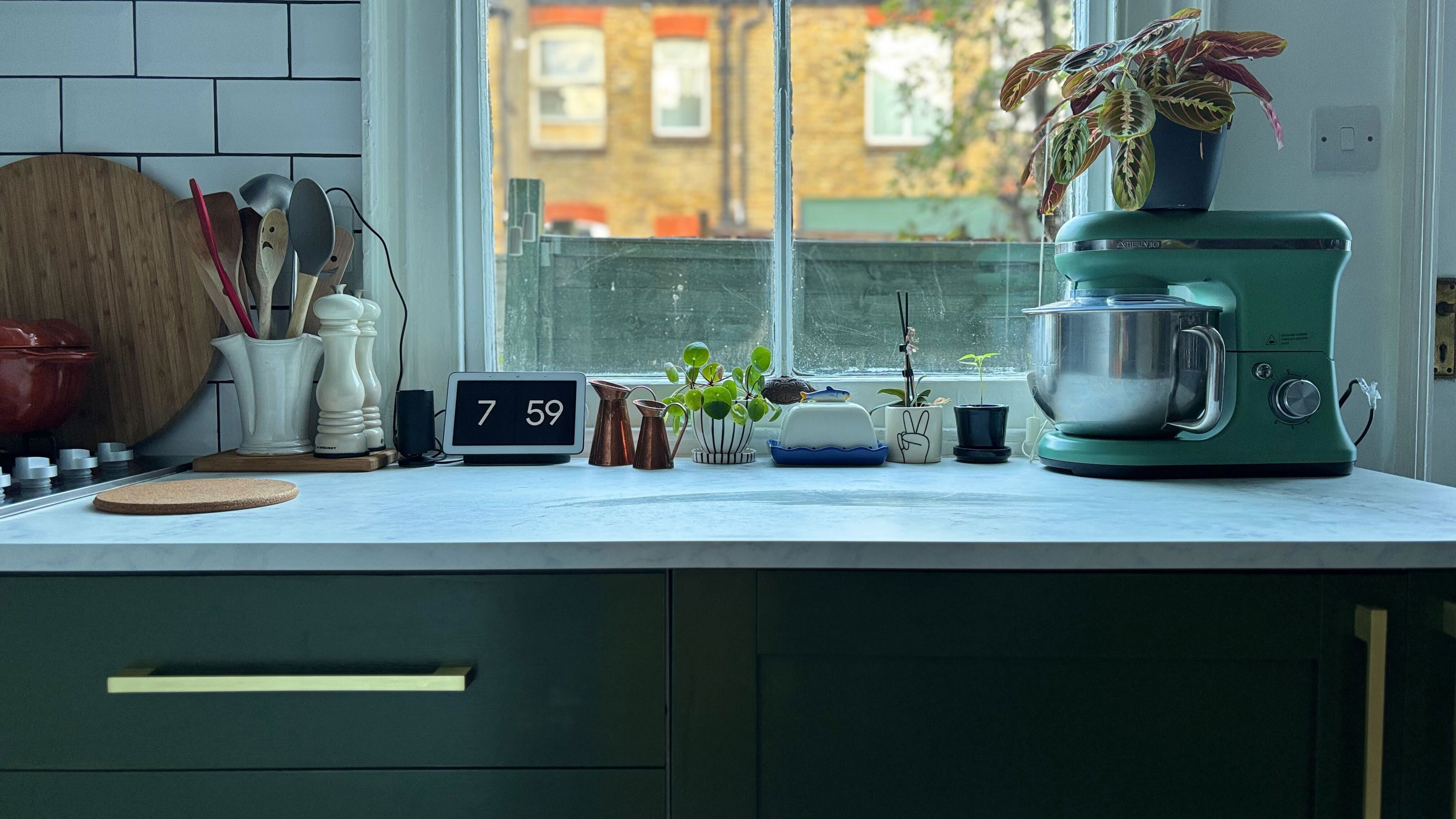 Green painted kitchen with gold handles and white countertops