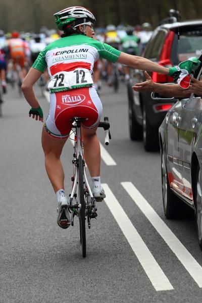 Monia Baccaille (SC MCipollini Giordana) gives her over-vest to the neutral service car