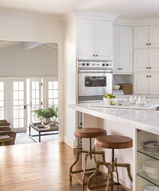 kitchen with white cabinets and island with bar stools and view to living room