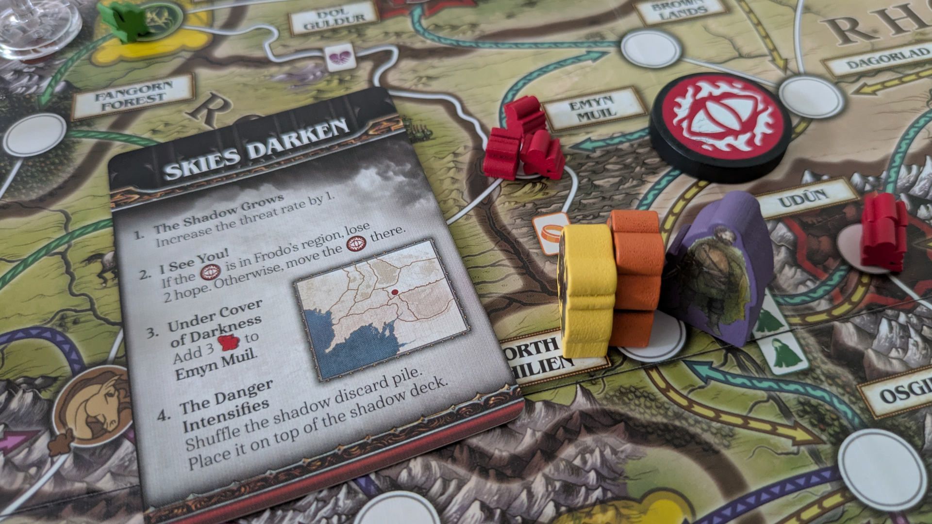 A card, tokens, and meeple on the Fate of the Fellowship board
