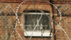 The window of a cell at Norwich Prison is seen through coils of razor wire