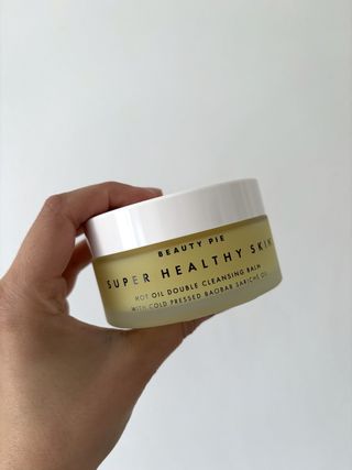 Mica holding the Beauty Pie Super Healthy Skin™ Hot Oil Double Cleansing Balm