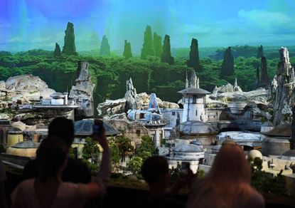 Fans view a model of the new Star Wars theme park that will open in the California and Florida Disneyland Parks in 2019 during the D23 expo fan convention