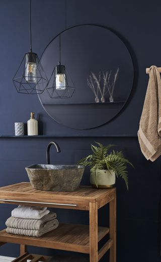 wooden vanity units with mirror and black pendant light in toilet