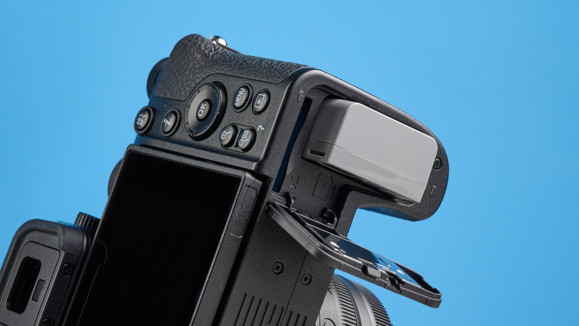 The Nikon Z50II battery compartment open with the battery half out