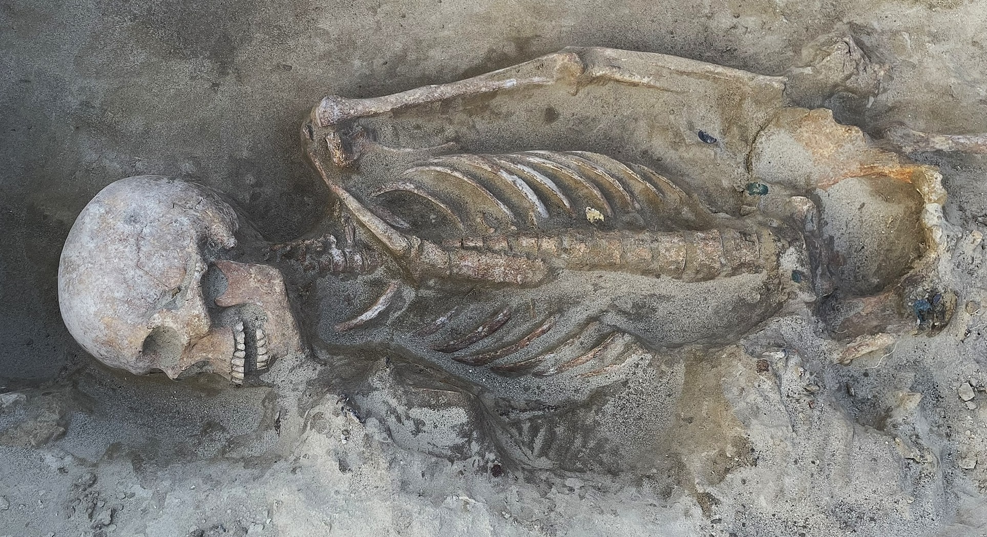 A skeleton of a man lying in the dirt