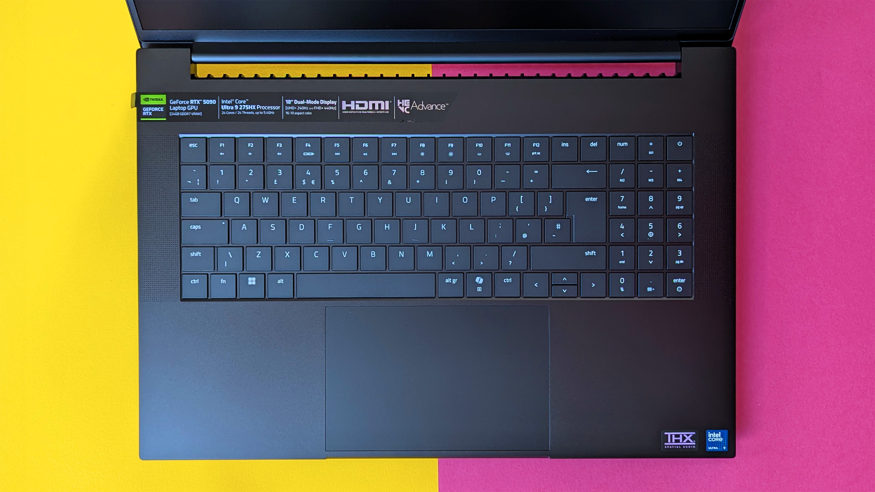 Razer Blade 18 (2025) gaming laptop on a pink and yellow background.