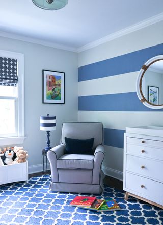 A bedroom with blue and white stripes painted on the wall