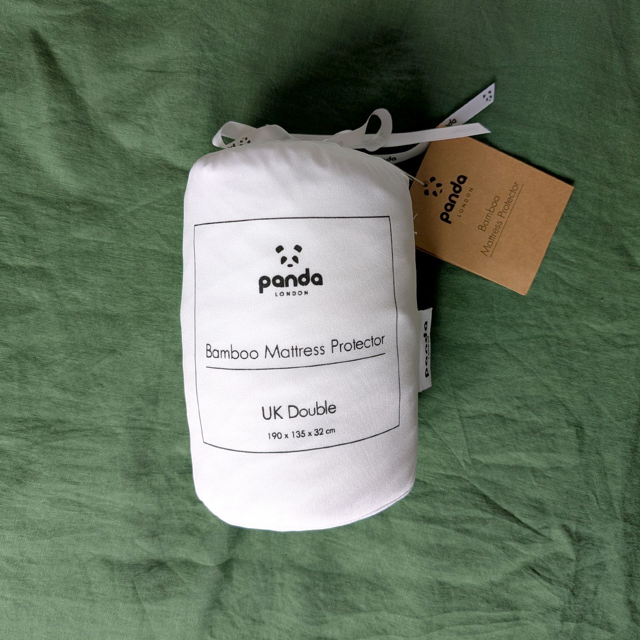 Panda mattress protector folded up into a white fabric bag with the Panda logo and product name.