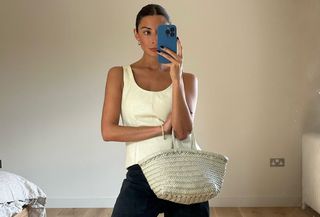 Woman in ivory tank top and woven bag