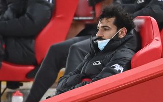 Liverpool forward Mohamed Salah looks dejected as he sits in the stands having been substituted