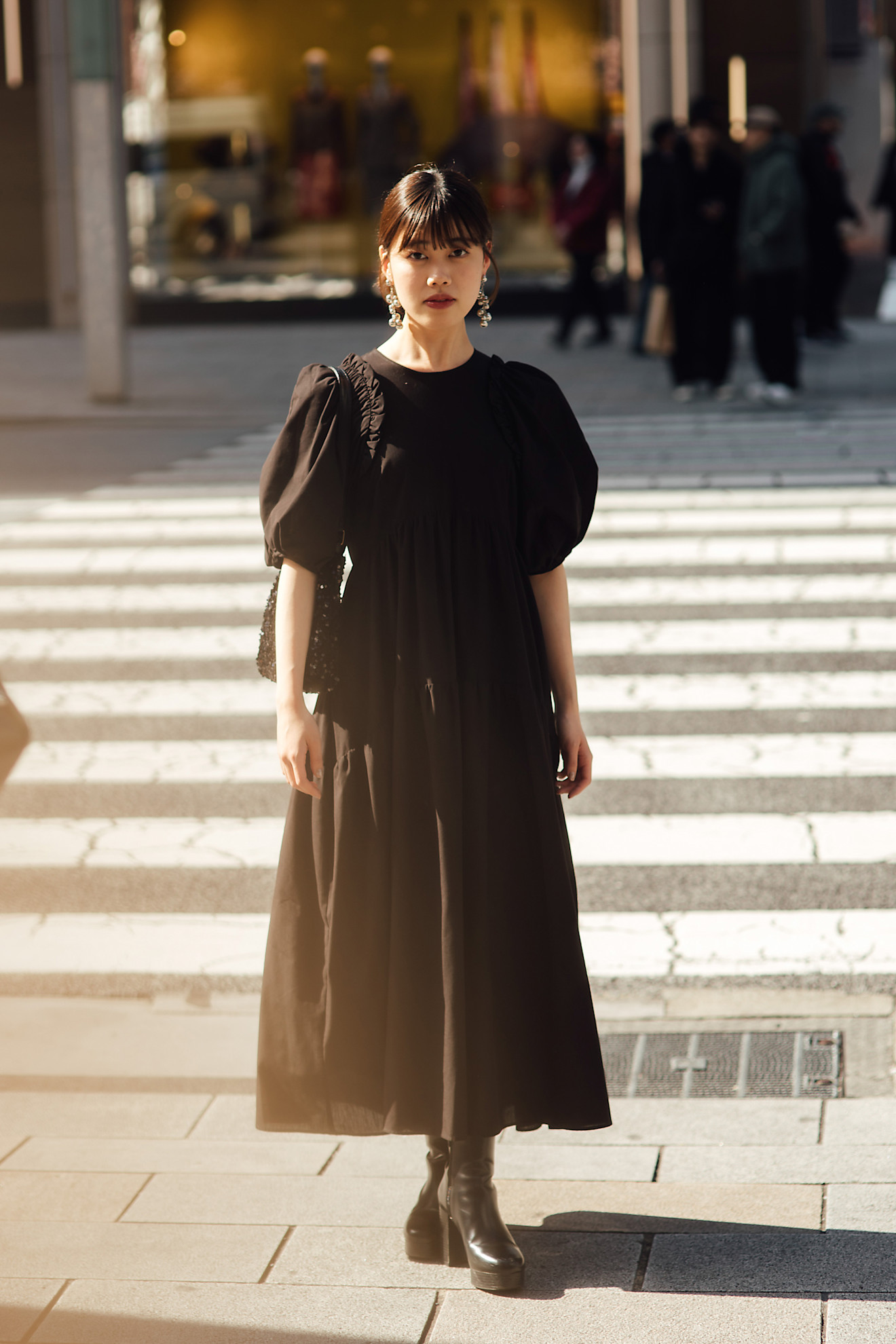 woman wearing a blakck dress and a pair of black boots.
